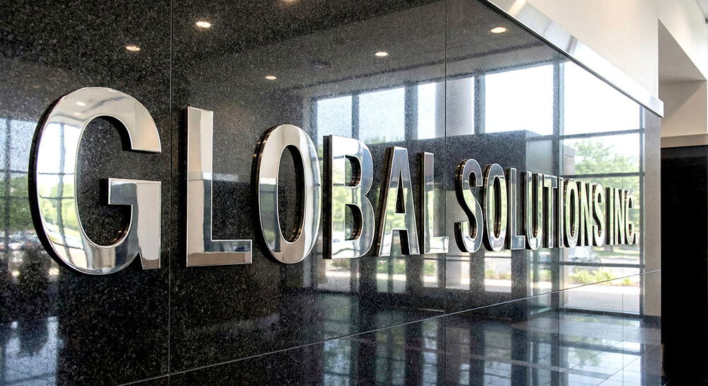 企業のオフィスエントランスにある鏡面仕上げの重厚なステンレス切文字